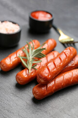 Wall Mural - Board with tasty grilled sausages on dark wooden background, closeup