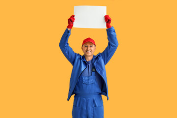 Canvas Print - Portrait of male mechanic with blank poster on orange background