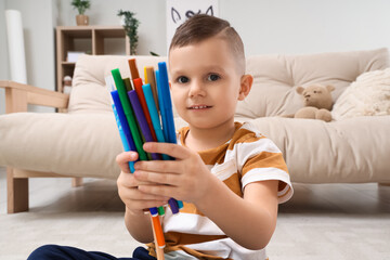 Sticker - Cute little boy drawing with felt-tip pens at home, closeup