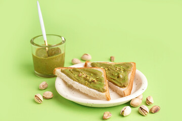 Wall Mural - Glass and bread pieces with tasty pistachio paste on green background