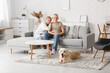 © Pixel-Shot - Mature couple with Labrador dog sitting on sofa at home