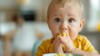 © LifeMedia - A child wearing a yellow shirt is happily enjoying a meal at the home table, creating a vibrant and joyful family dining scenario, highlighting the simple pleasures of childhood.
