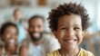 © LifeMedia - A smiling child who is the center of attention in focus, with family members behind in a warmly lit indoor setting, showcasing familial love and connection.