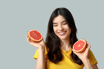 Sticker - Beautiful young woman with grapefruit on grey background