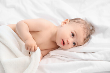 Canvas Print - Cute little baby with towel lying on bed after bathing, closeup