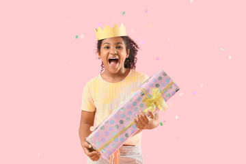 Sticker - Happy African-American girl with gift box, crown and confetti on pink background. Birthday celebration