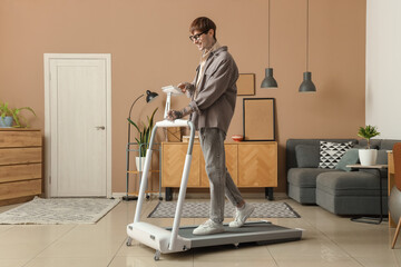 Sticker - Young man using tablet computer on treadmill in office