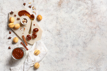 Wall Mural - Board with tasty walnut shaped cookies, boiled condensed milk and ingredients on white grunge table