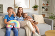 © Pixel-Shot - Cute little children with their mother watching cartoons on TV at home