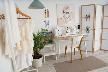 Poster - Interior of light atelier with tailor's workplace, clothes rack and folding screen