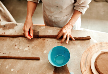 Person, hands and tool in workshop for pottery or ceramic creativity, form design and surface decoration or details. Artist, closeup and texture creation on clay for art, manufacturing and handmade.