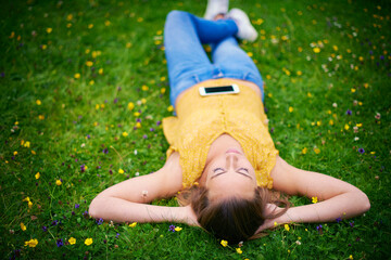 Sticker - Woman, relax and grass in park field, calm and happiness in spring for weekend break with student on holiday. Laying, sleep and resting in nature on ground, female person and peaceful outside