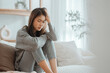 © oatawa - Depressed young woman sitting on couch in the living room at home, Frustrated confused female feels unhappy problem in personal life quarrel break up with boyfriend, copy space