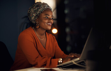 Canvas Print - Black woman, business and laptop as entrepreneur with working late, happy and confident in office. Female person, tech and night for overtime, deadline or project in editing as online content creator