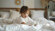 © ibooM - Little girl crawls on the bed against the background of a bedroom