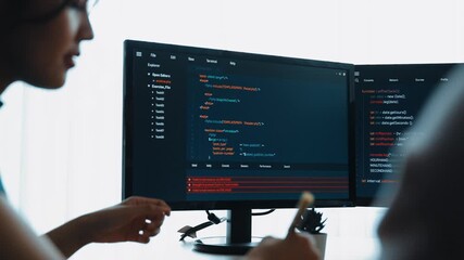 Slow motion back end software developer engineer for computer programming working together on debugging writing computing code, solving complex algorithms display on monitor in office. Burgeoning