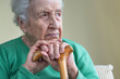 © berna_namoglu - portrait of a senior woman leaning on a wooden cane while thinking