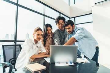 Wall Mural - Asian project manager uses laptop displayed data analysis while professional business team brainstorming marketing idea at business meeting. Working together,sharing idea, planing strategy. Tracery.