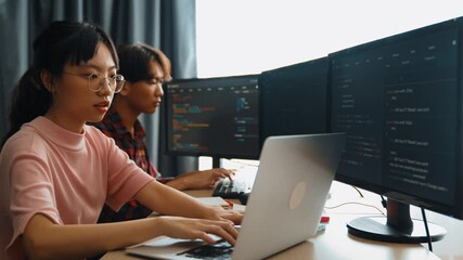 Slow motion back end software developer engineer for computer programming working together on debugging writing computing code, solving complex algorithms display on monitor in office. Burgeoning