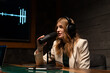 © Big Shot Theory - A young woman is hosting a podcast in a modern studio, speaking into a microphone