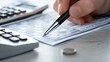 © Art Genie - Detailed View of Traditional Banking Process with Person Writing a Check on a Clean Desk with Calculator and Checkbook