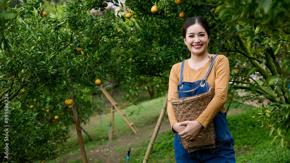 Young Asian woman in denim overalls holding a wicker basket, standing ...