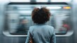 © Dulemegapixel - A person standing on the subway platform waiting for the train to arrive, with the train in motion and creating a blurred effect, symbolizing patience and anticipation.