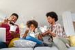 © NDABCREATIVITY - Happy african family eating at living room and enjoying time together. Home delivary takeaway food