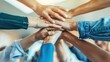 © furyon - diverse group of hands stacked in unity gesture soft focus office background emphasizes teamwork and collaboration concept