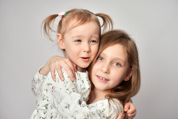 Wall Mural - A portrait of two sisters on a white background with copy space. Happy children having fun together.