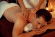 © InfiniteFlow - Caucasian man customer enjoying relaxing anti-stress spa massage and pampering with beauty skin recreation leisure in warm candle lighting ambient salon spa at luxury resort or hotel. Quiescent