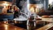 © Sergey - Person cooking in a modern kitchen with steam rising from sauteing