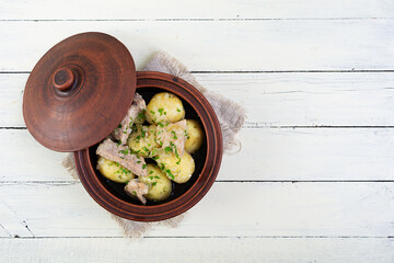 Wall Mural - Stewed potatoes with meat, onions and herbs in a jug