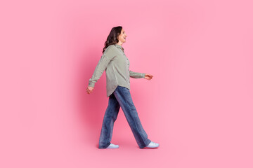 Wall Mural - Full body profile portrait of pretty aged lady walk empty space wear shirt isolated on pink color background