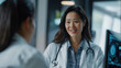 © Chatchanan - An Asian female doctor explaining medical test results on a digital screen to a patient, with a reassuring smile.