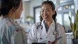 © Chatchanan - An Asian female doctor smiling while showing a digital screen to a patient, explaining test results at a medical clinic.