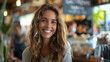 © khonkangrua - Young woman with long hair smiling brightly in a cozy, bustling coffee shop environment, exuding warmth and happiness.