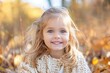 © ChaoticMind - A young girl with bright blue eyes and blonde hair smiles joyfully while sitting outdoors amidst beautiful autumn leaves, wearing a cozy knit sweater.