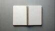 © DigitalArt Max - Blank white notebook with crisp pages lies open on a minimalist grey background, ready for creative expression.