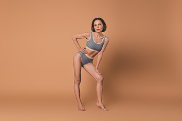 Poster - No filter photo of charming lovely woman posing athletic sporty shape isolated on beige color background