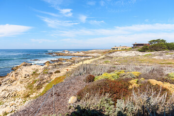 Oceanfront houses along a deserted coastal path on a sunny autumn day