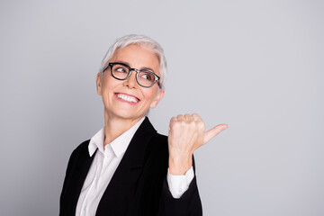 Poster - Photo of charming lovely senior lady wear black suit demonstrate proposition empty space isolated on grey color background