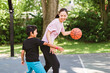 © Louis-Photo - Basketball, family and teaching sport with a mom and son training on a court outside for leisure fitness and fun