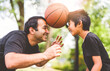© Louis-Photo - Basketball, family and teaching sport with a dad and son training on a court outside for leisure fitness and fun