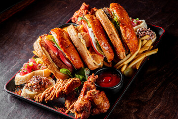 Poster - A colorful platter of fast food items including burgers, fries, and fried chicken on a dark wooden table