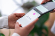 © Studio Marmellata - A close-up of a tap to pay mobile payment transaction between two people, with one phone displaying The scene emphasizes the simplicity and efficiency of digital payments