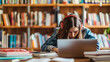 © Maestro - Teenage girl studying in library with laptop and textbooks