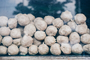 A pile of white meatballs stacked on top of each other. The balls are all the same size and shape.