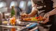 © Matthias - Close-up of flight attendant's hands serving tray of drinks and snacks