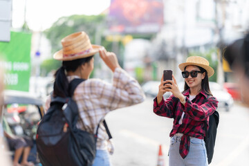 Two young female tourists in the sunny city center Lively Asian woman in Thailand with beautiful beaming smile along a busy street, travel concept